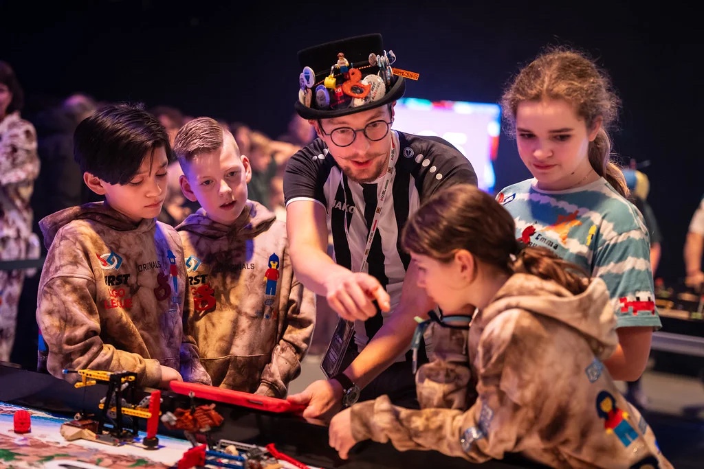 Jongeren en een begeleider bij een LEGO-robot tijdens de FIRST LEGO League